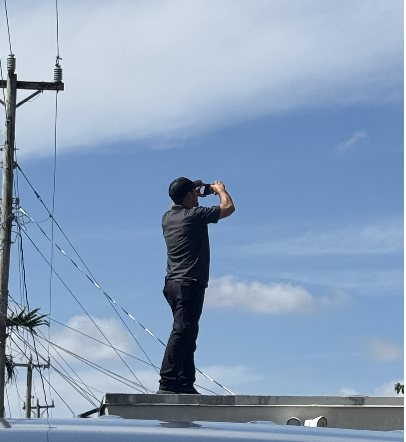 Jorge Garcia photographing a South Florida roof to document wind mitigation features