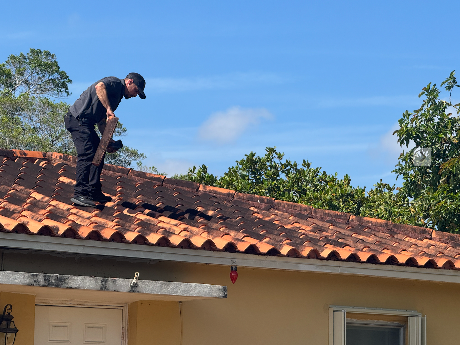 Jorge Garcia inspecting a terracotta tile roof on a South Florida home