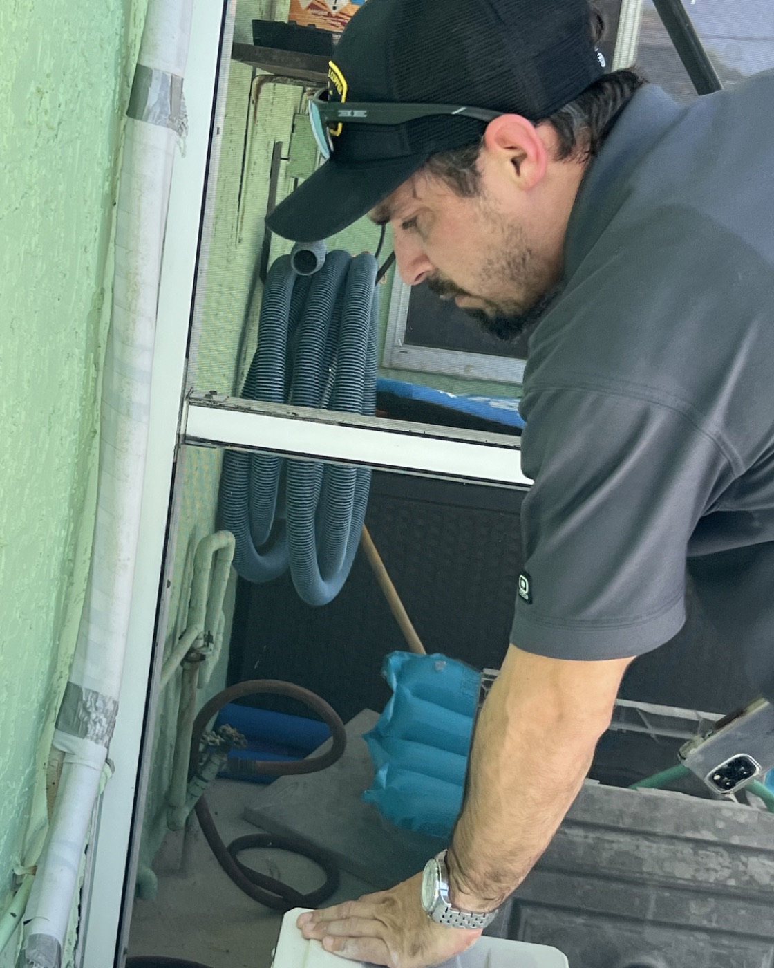 Jorge Garcia inspecting a window air-conditioning unit
