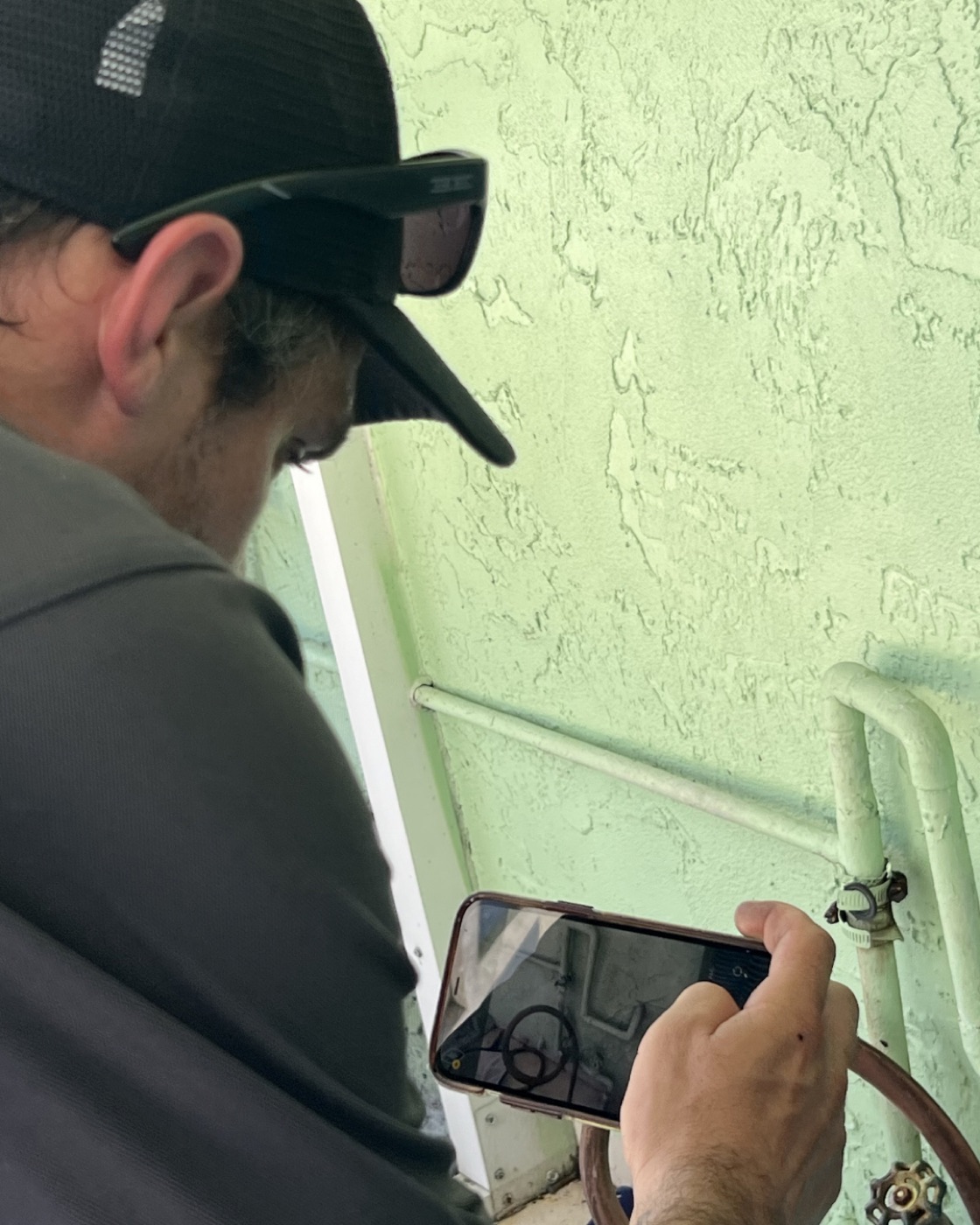 Jorge Garcia photographing a finding on his phone during an inspection